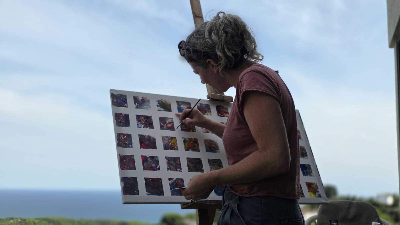 Camille painting outdoors at an easel in the garden